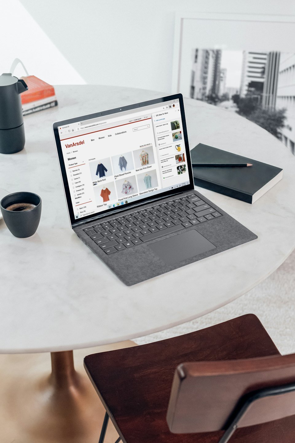 Laptop menampilkan situs web e-niaga di atas meja marmer.